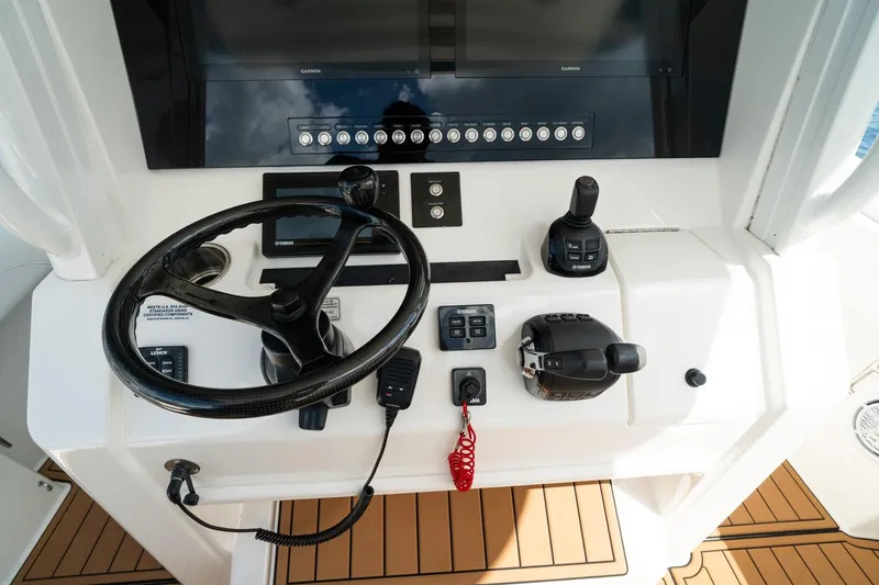 Slide: The Image of 2020 Regulator 31 boat helm with steering wheel, controls, and Garmin display. - 41