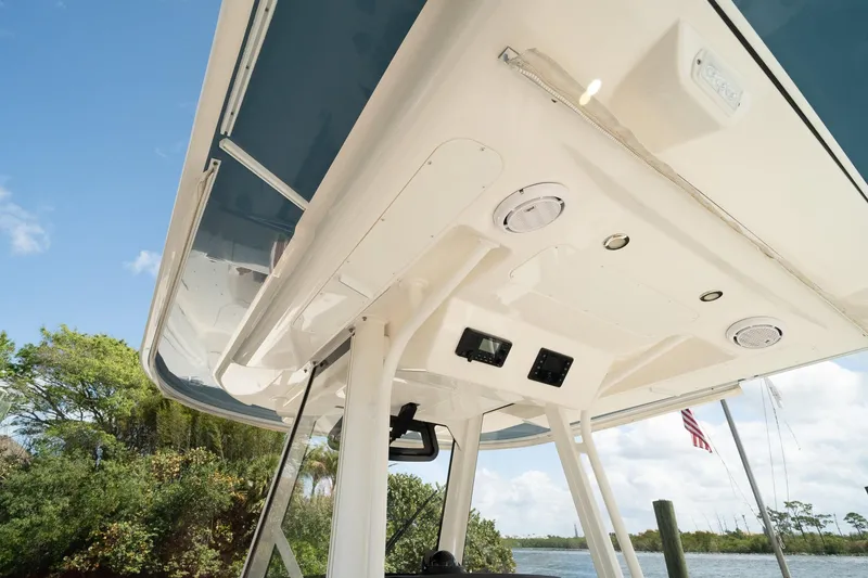 Slide: The Image of 2020 Regulator 31 boat canopy with speakers and electronics, set against a scenic waterway. - 44