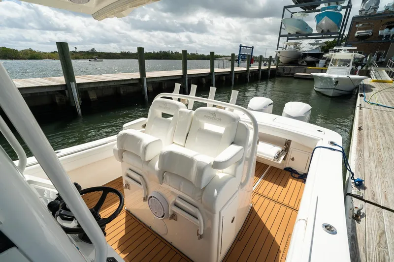 Slide: The Image of 2020 Regulator 31 boat interior with white seating at a marina dock. - 47