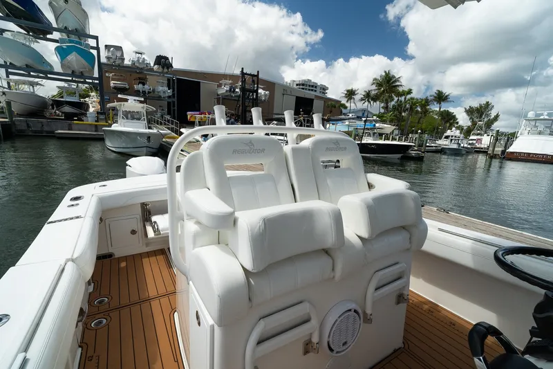 Slide: The Image of 2020 Regulator 31 boat interior with white seating at a marina. - 48
