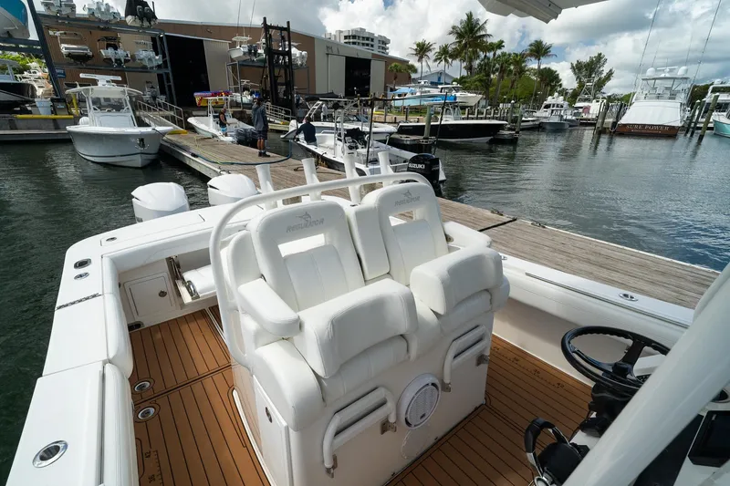 Slide: The Image of 2020 Regulator 31 boat docked at marina with white seating and wooden deck. - 49