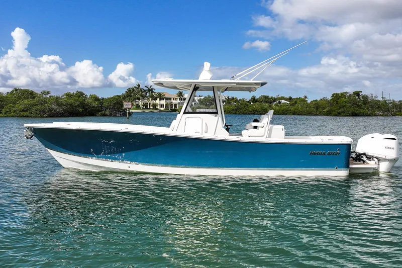 Slide: The Image of 2020 Regulator 31 boat on water, blue hull, clear sky background. - 5