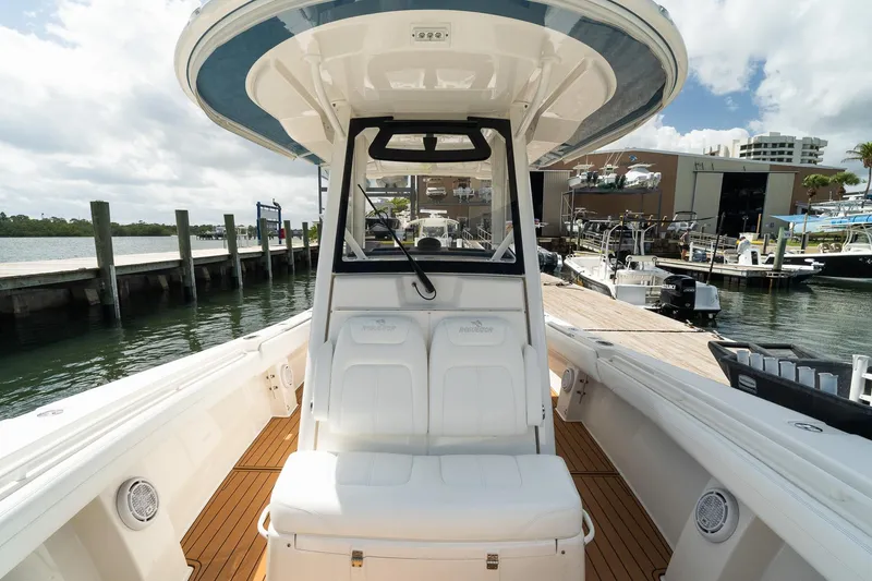 Slide: The Image of 2020 Regulator 31 boat docked at marina, featuring spacious seating and sleek design. - 54