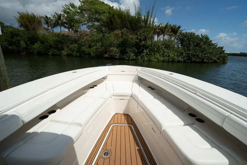 Slide: The Image of 2020 Regulator 31 boat with spacious seating, docked near lush greenery. - 57