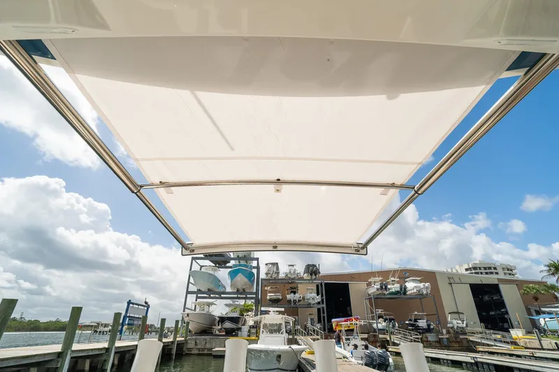 Slide: The Image of 2020 Regulator 31 boat with sunshade at marina, clear sky background. - 69