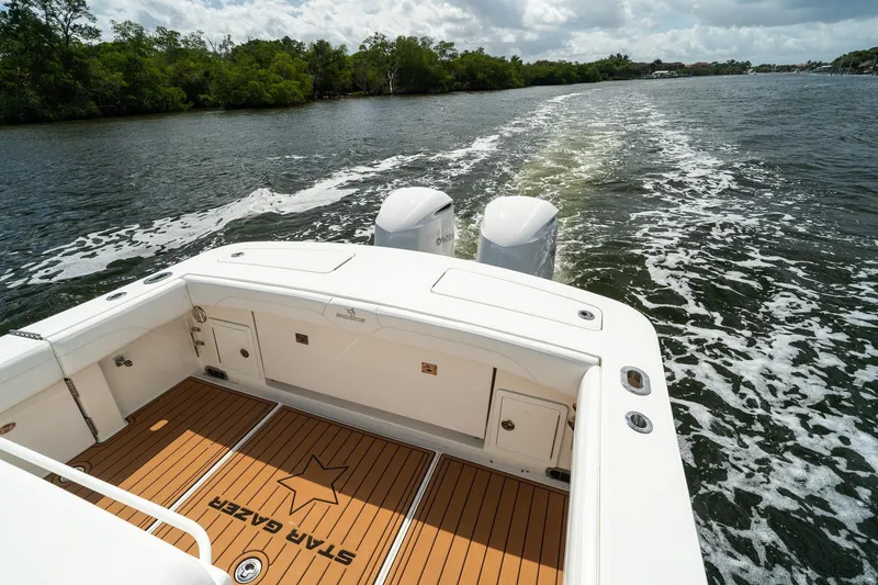 Slide: The Image of 2020 Regulator 31 boat cruising on a scenic waterway with lush greenery. - 8