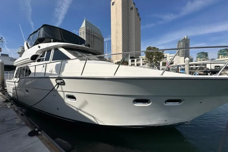 The Image of 1999 Bayliner 5788 Pilot House Motoryacht docked in urban marina setting. - 0