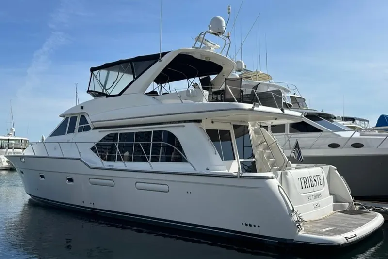 Slide: The Image of 1999 Bayliner 5788 Pilot House Motoryacht docked at marina, side view. - 1