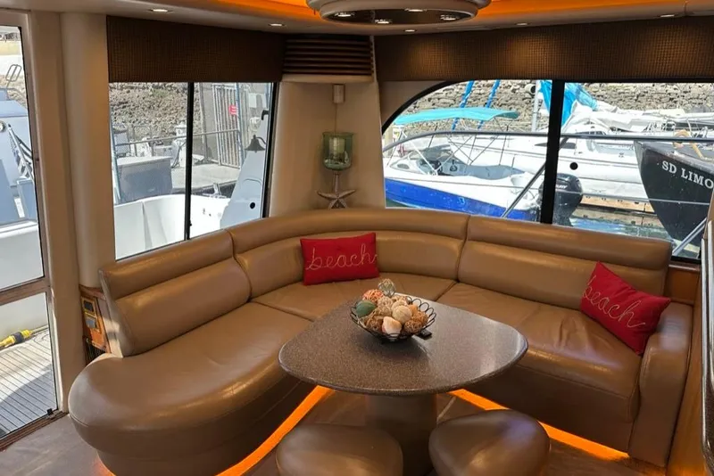 Slide: The Image of Luxurious interior of 1999 Bayliner 5788 Pilot House Motoryacht with leather seating and marina view. - 11