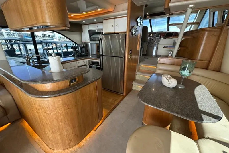 Slide: The Image of Luxurious interior of a 1999 Bayliner 5788 Pilot House Motoryacht with modern kitchen and seating area. - 17
