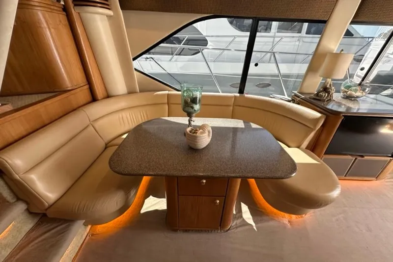 Slide: The Image of Luxurious interior of 1999 Bayliner 5788 Pilot House Motoryacht with elegant seating and table. - 18