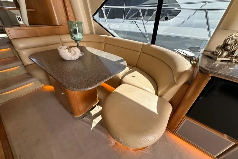 Slide: The Image of Luxurious interior of 1999 Bayliner 5788 Pilot House Motoryacht with elegant seating and table. - 19