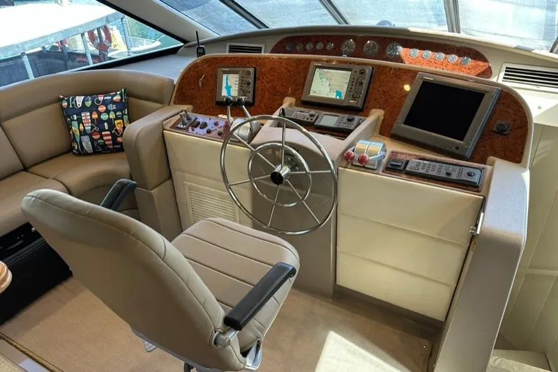 Slide: The Image of 1999 Bayliner 5788 Pilot House Motoryacht helm with navigation screens and steering wheel. - 29