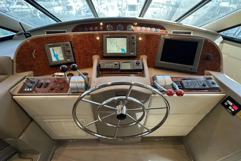 Slide: The Image of 1999 Bayliner 5788 Pilot House Motoryacht helm with navigation screens and controls. - 34