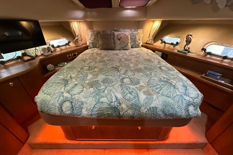 Slide: The Image of Luxurious bedroom in 1999 Bayliner 5788 Pilot House Motoryacht with seashell-themed bedding. - 44