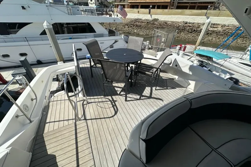 Slide: The Image of 1999 Bayliner 5788 Pilot House Motoryacht deck with seating and table, docked at marina. - 46