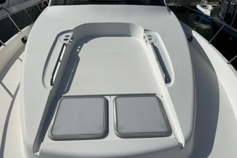 Slide: The Image of 1999 Bayliner 5788 Pilot House Motoryacht deck with hatches and railings in marina. - 67