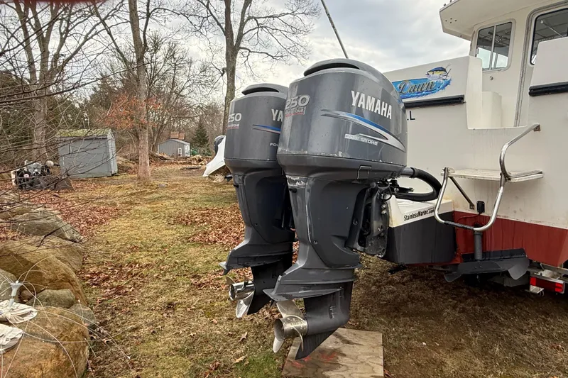 Slide: The Image of Twin Yamaha outboard motors on a 2005 Osprey 28 Long Cabin boat, parked outdoors. - 2