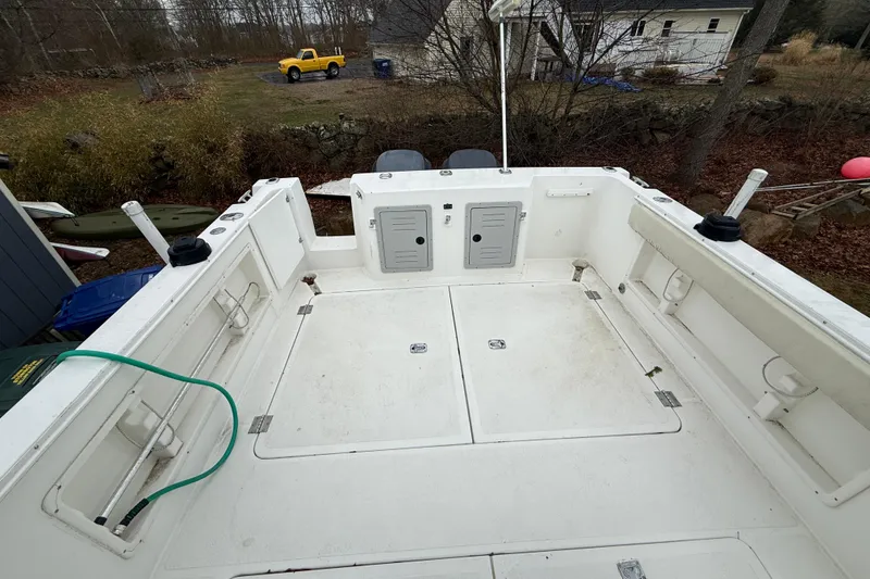 Slide: The Image of 2005 Osprey 28 Long Cabin boat deck with storage compartments and rod holders. - 6