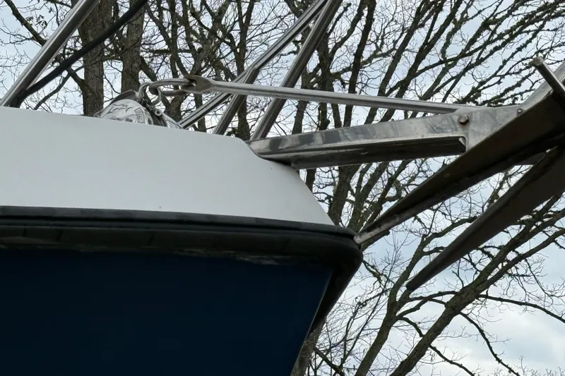 Slide: The Image of Bow of 2005 Osprey 28 Long Cabin boat with anchor, against tree backdrop. - 8