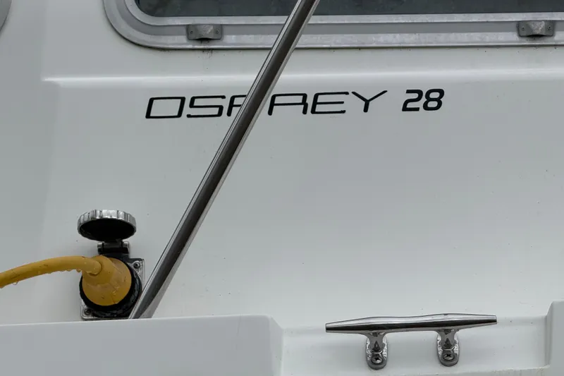 Slide: The Image of Close-up of a 2005 Osprey 28 Long Cabin boat with visible logo and hardware. - 9