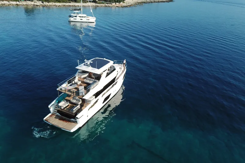 Slide: The Image of Aerial view of 2026 Absolute Navetta 70 yacht cruising in clear blue waters. - 5