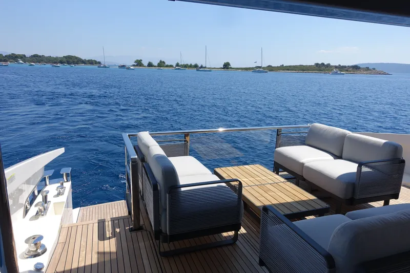 Slide: The Image of Luxury deck view on Absolute Navetta 70 yacht, 2026 model, overlooking serene blue waters. - 21