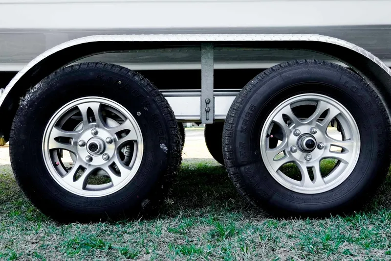 Slide: The Image of Trailer wheels of a 2026 Tidewater 2110 Bay Max boat on grass. - 39