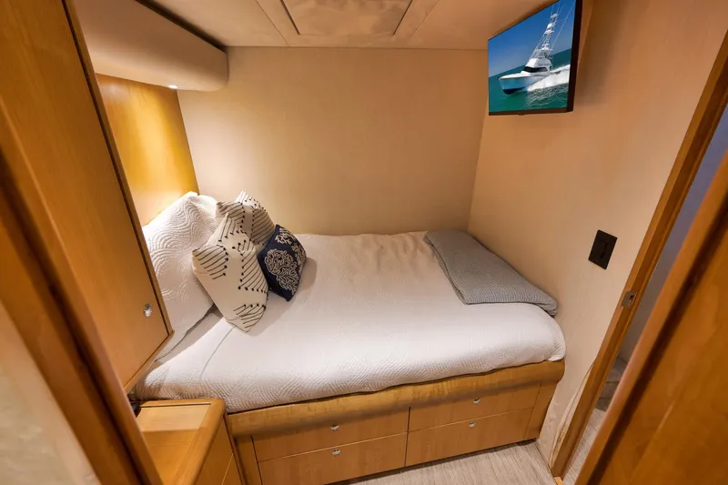 Slide: The Image of Cozy cabin interior of 2003 Weaver Custom Sportfish with bed, pillows, and wall-mounted TV. - 25