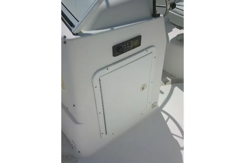 Slide: The Image of 2006 Clearwater 2200 Dual Console boat interior with control panel and storage compartment. - 17