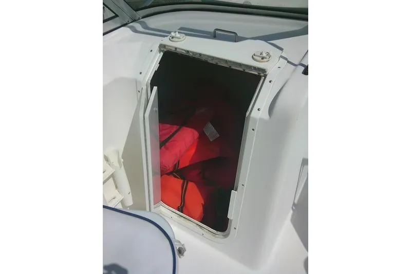 Slide: The Image of Open storage compartment on 2006 Clearwater 2200 Dual Console boat with life jackets inside. - 28