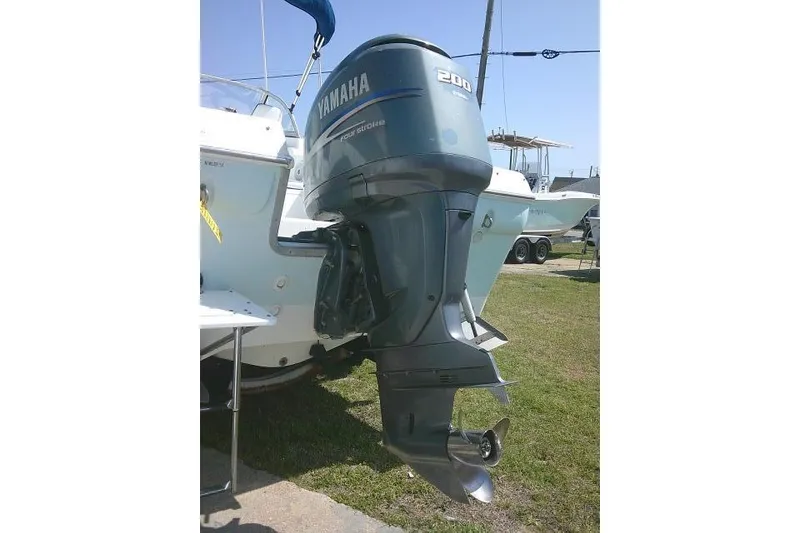 Slide: The Image of Outboard motor on a 2006 Clearwater 2200 Dual Console boat, parked on grass. - 6