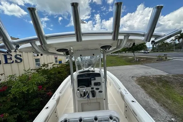 Slide: The Image of 2014 Pioneer 222 Sportfish boat with T-top and console, parked outdoors. - 11