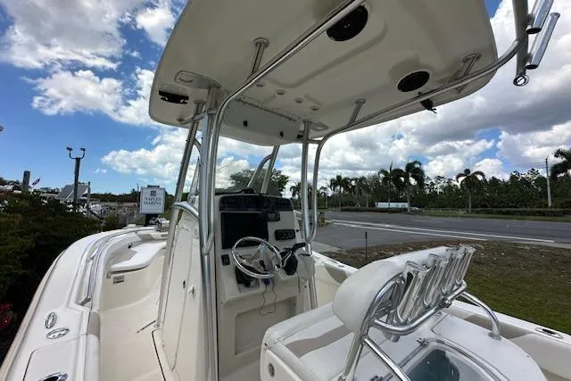 Slide: The Image of 2014 Pioneer 222 Sportfish boat with T-top and console, under a partly cloudy sky. - 12