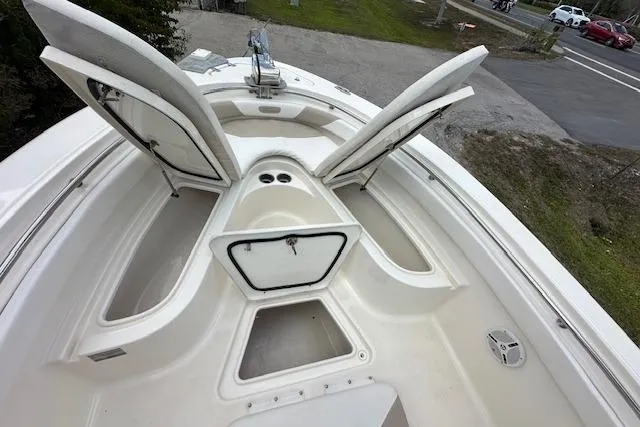 Slide: The Image of 2014 Pioneer 222 Sportfish boat with open storage compartments and clean deck. - 15