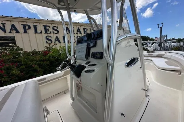 Slide: The Image of 2014 Pioneer 222 Sportfish boat interior with steering console, Naples Marina in background. - 19