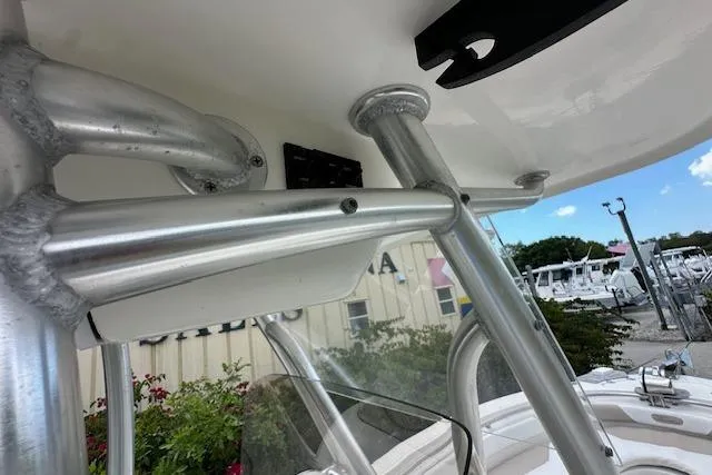 Slide: The Image of 2014 Pioneer 222 Sportfish boat with sturdy metal framework and clear windshield, docked outdoors. - 20