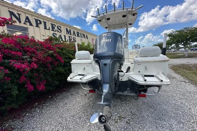 Slide: The Image of 2014 Pioneer 222 Sportfish boat at Naples Marina Sales, featuring a powerful outboard motor. - 22