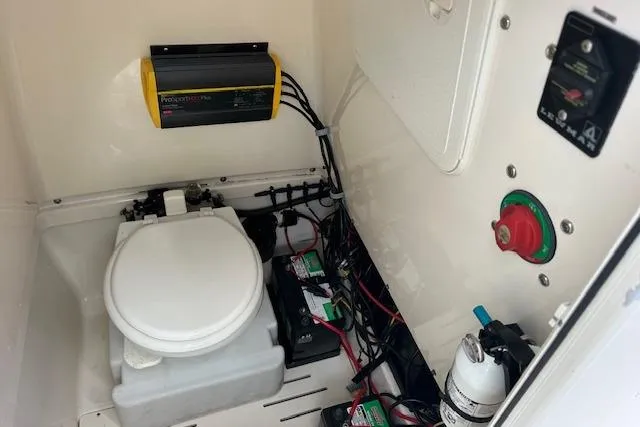 Slide: The Image of Interior of 2014 Pioneer 222 Sportfish boat showing toilet, batteries, and electrical components. - 4
