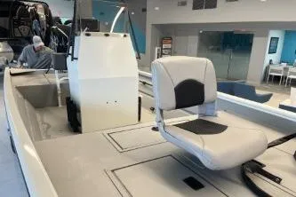 Slide: The Image of 2026 Crestliner 1860 Retriever CC boat interior with seating and console in showroom. - 10