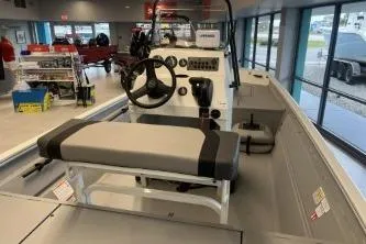 Slide: The Image of 2026 Crestliner 1860 Retriever CC boat interior with steering console and seating in showroom. - 8