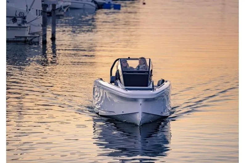 Slide: The Image of 2027 Axopar 22 Spyder cruising on calm water at sunset. - 3