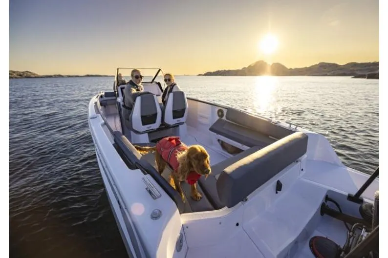 Slide: The Image of 2027 Axopar 22 Spyder boat cruising at sunset with passengers and a dog. - 8