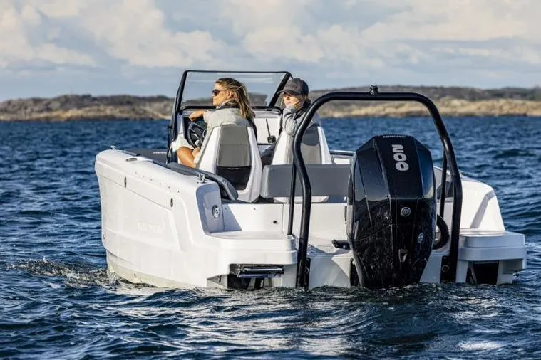 Slide: The Image of 2027 Axopar 22 Spyder cruising on open water with two passengers. - 9