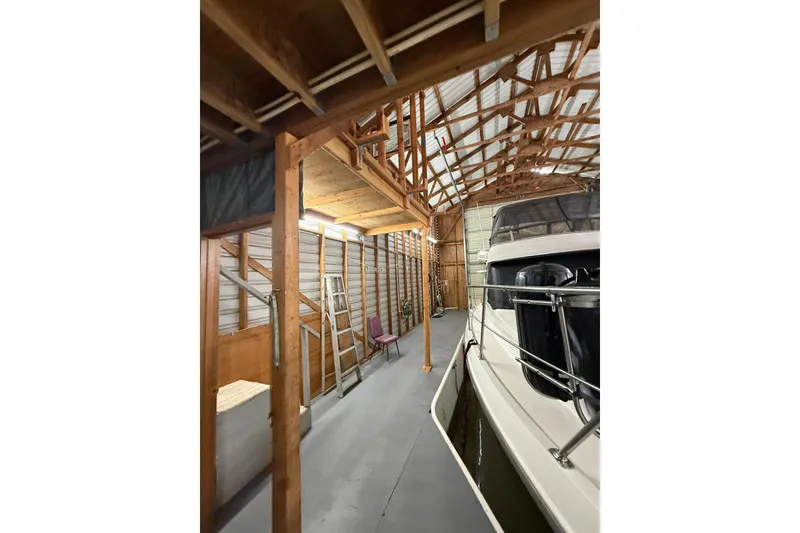 Slide: The Image of Interior of a 2008 Custom Hargraves boathouse with docked boat and wooden beams. - 5