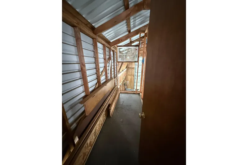 Slide: The Image of Narrow wooden interior of a 2008 Custom Hargraves boathouse with metal siding. - 8