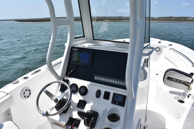 Slide: The Image of 2023 Tidewater 232 CC Adventure boat dashboard with steering wheel and navigation display. - 10