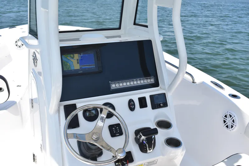 Slide: The Image of 2023 Tidewater 232 CC Adventure boat console with steering wheel and navigation display. - 12