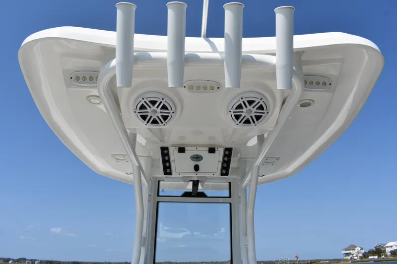 Slide: The Image of 2023 Tidewater 232 CC Adventure boat's T-top with rod holders and speakers. - 14