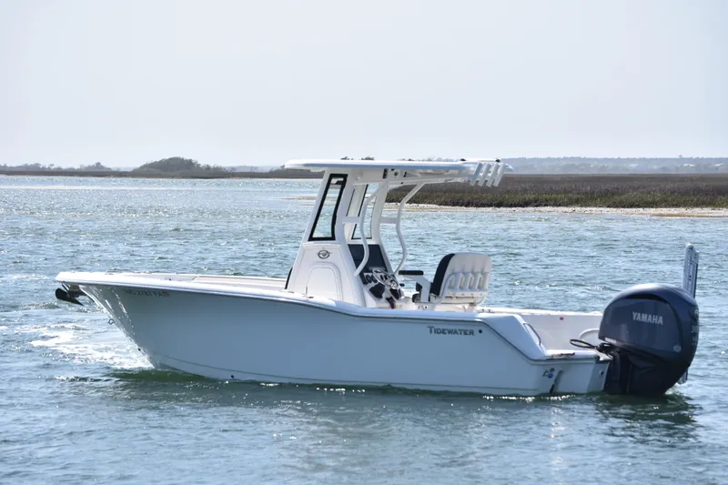 Slide: The Image of 2023 Tidewater 232 CC Adventure boat cruising on a calm waterway. - 3